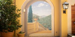 A painted archway reveals a scenic view of rolling hills, potted plants, and a warm, inviting atmosphere, suggesting tranquility and beauty.