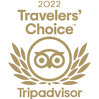 A gold emblem featuring the text "2022 Travelers' Choice" along with the Tripadvisor logo surrounded by laurel leaves.