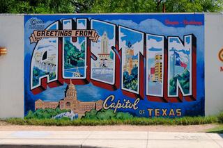 A vibrant mural features the phrase "Greetings from Austin" in bold letters, showcasing iconic landmarks and the phrase "Capital of Texas."