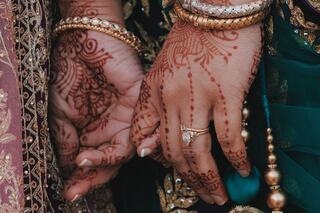 Intricate henna designs adorn hands, showcasing elegance and cultural beauty, while adorned with traditional jewelry and vibrant textiles.