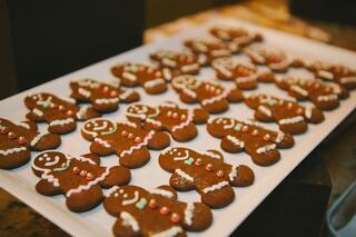 A tray filled with festive gingerbread cookies shaped like gingerbread men, decorated with frosting and colorful candy.