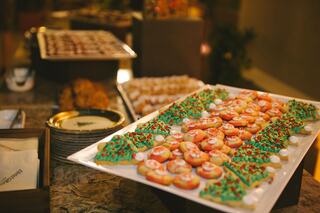 A festive assortment of colorful holiday cookies shaped like trees and decorated with icing and sprinkles, elegantly arranged on platters.