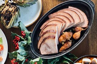 Tender slices of ham served alongside roasted vegetables and festive greens, creating a warm, inviting holiday meal setting.